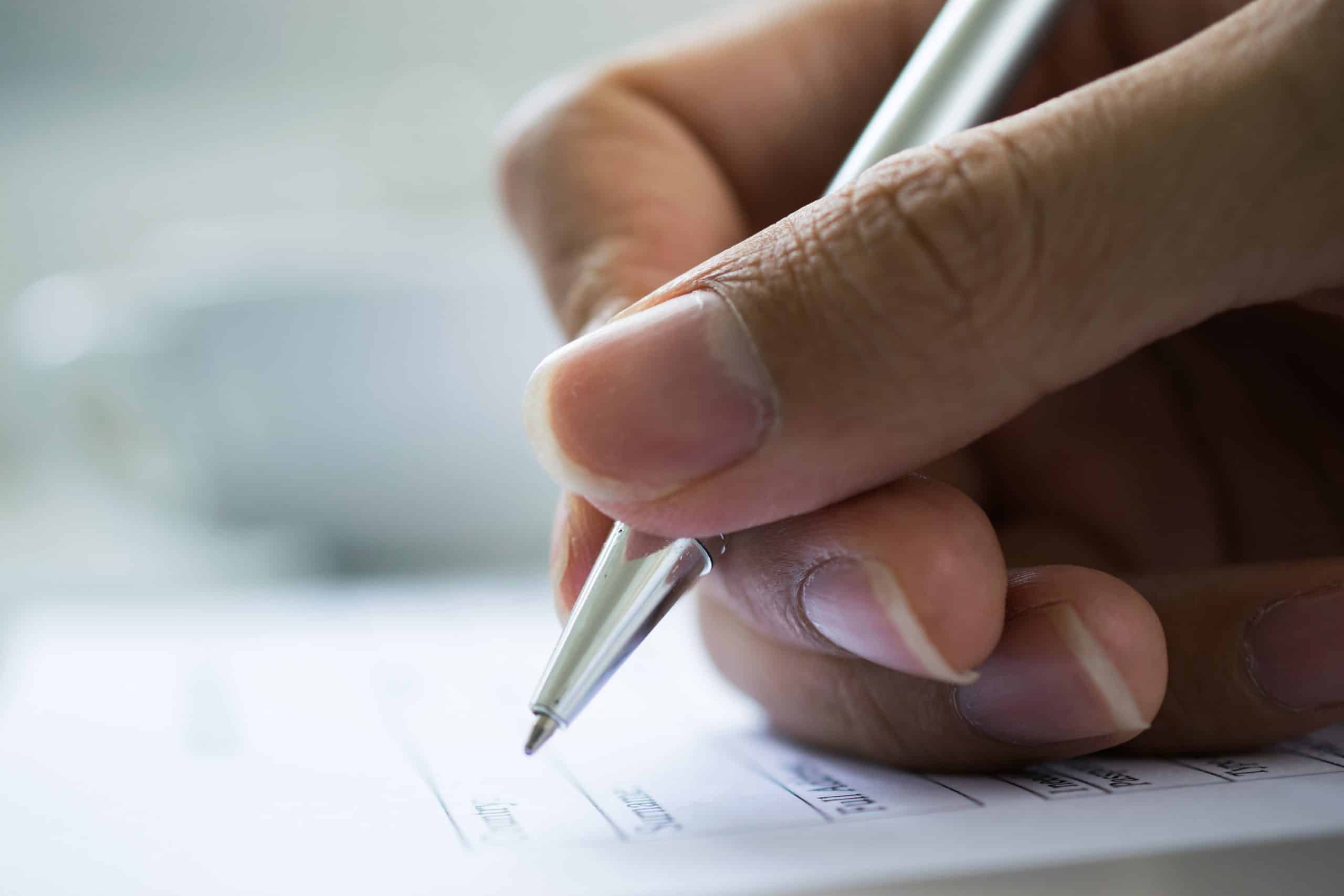 hand with pen over checklist form